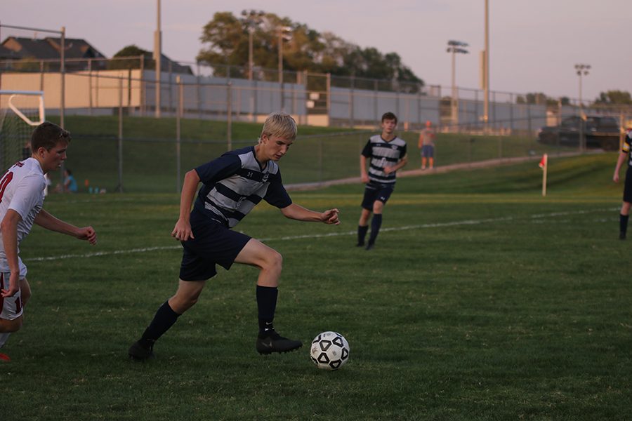 Sophomore Sutton Sick breaks away from an opponent and dribbles the ball down the field. 