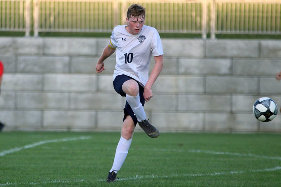 After kicking the ball, senior Will Coacher watches it fly through the air.