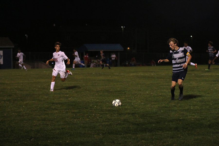 Getting ready to kick the ball downfield, senior Ian Carroll focuses and lines up with the ball. 