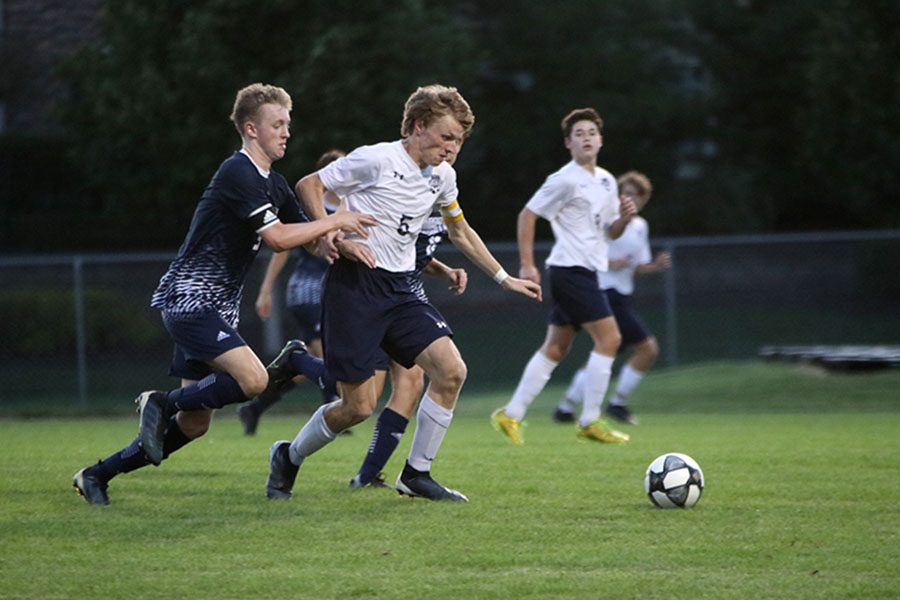 Breaking away from his opponents, senior Ian Carroll dribbles the ball down the field.