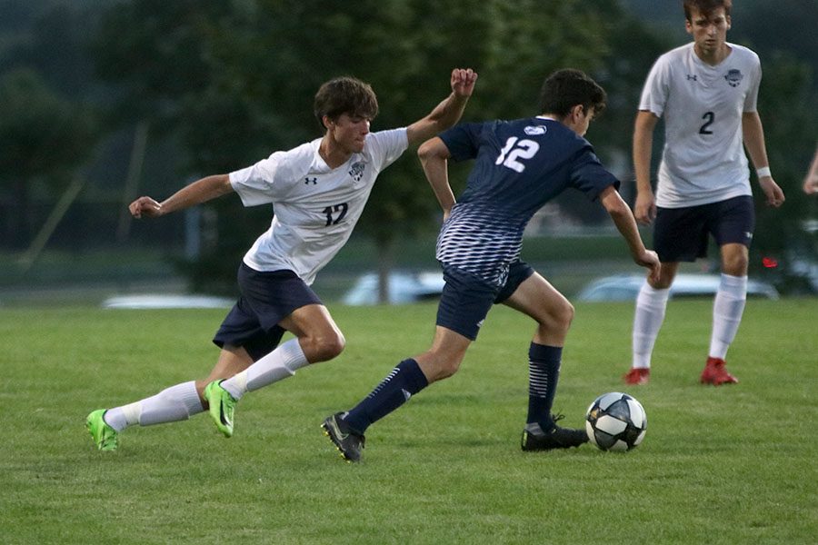 Taking long strides forward, senior Anthony Pentola runs toward the ball.