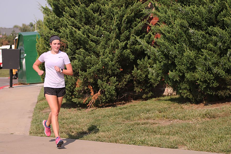 Less than two months after her open-heart surgery, sophomore Logan Pfeister finishes her run at cross country practice. 