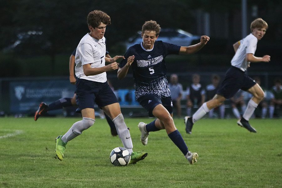 Catching up with his opponent, sophomore Yahel Anderson attempts to retrieve the ball.