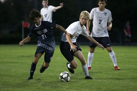 Attempting to block his opponent, sophomore Sutton Sick tries to steal the ball.