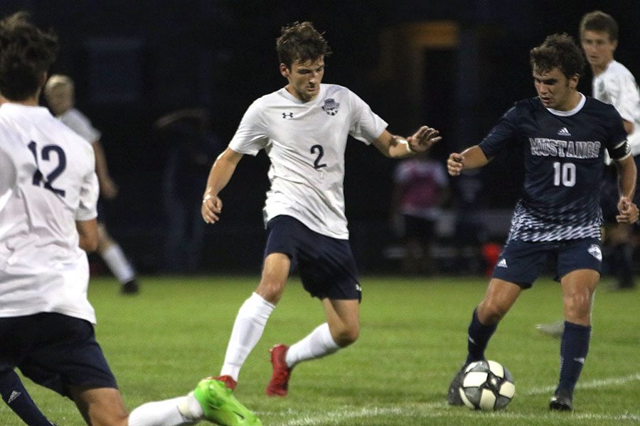 Trying to gain control of the ball, senior Riley Ferguson maneuvers around his opponent.