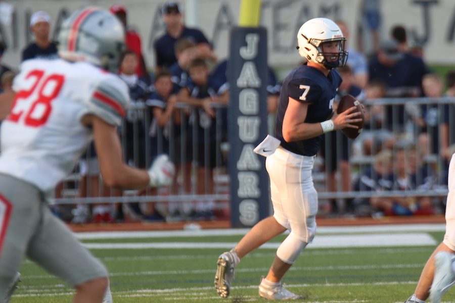 Quarterback Cooper Marsh rolls out to his left, keeping his eyes downfield. In his first start at quarterback, the junior threw for 100 yards and a touchdown in a 28-21 loss to Blue Valley West Friday, Sept. 6.