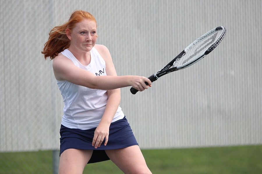 Following through on a forehand hit, sophomore Lauren Butler returns the ball to her opponent. She and teammate Carli Dupriest won this match against Olathe Northwest on Wednesday, September 4. 