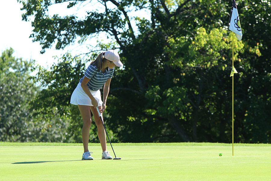  Focusing on her stroke, Sophomore Charley Strahm putts the ball towards the hole at Sunflower Hills Golf Course on Monday, September 3rd.