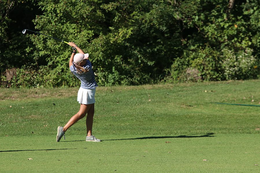 Looking at her ball, junior Megan Haymaker follows through with her swing.
