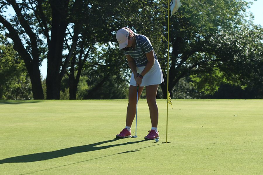 Putter in hand, sophomore Libby Green putts the ball.
