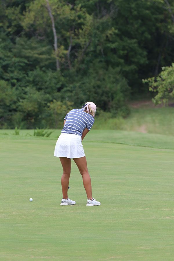 Swinging the club, senior Hannah Davie putts the ball on the green. Davie won fourth place on Tuesday, Sept. 10.