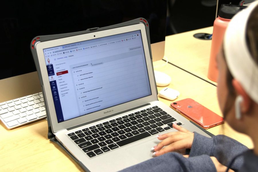 A student uses her her school-issued MacBook Air to do school work on the program Canvas during seminar on Monday, Sept. 9.
