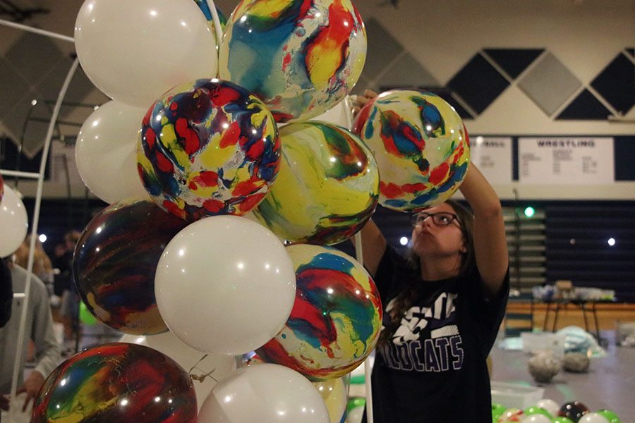 Junior+Katherine+Weigel+ties+balloons+together+to+create+a+balloon+arch.+