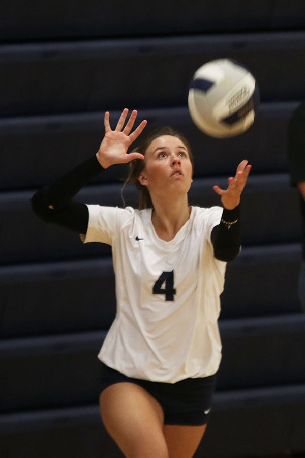 Eyes locked on the ball, senior Emma Fox serves.