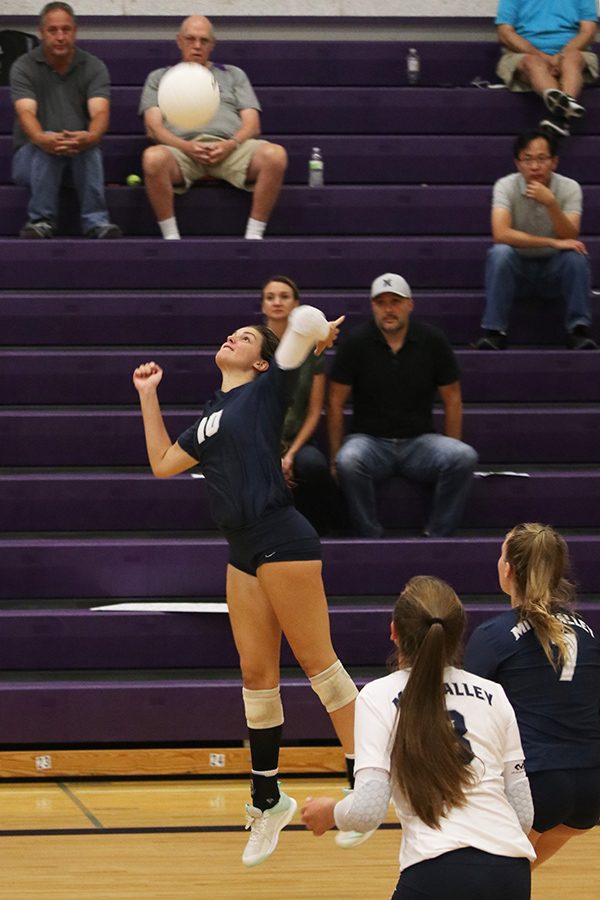 In the air, junior Molly Carr prepares to hit the ball.