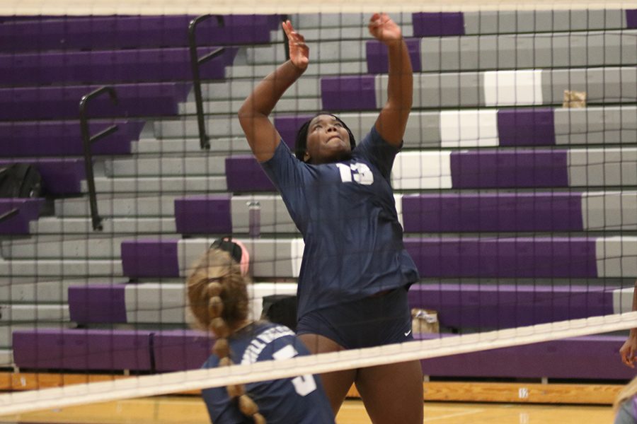 In the front row, sophomore Tayler Roberts jumps to hit the ball.