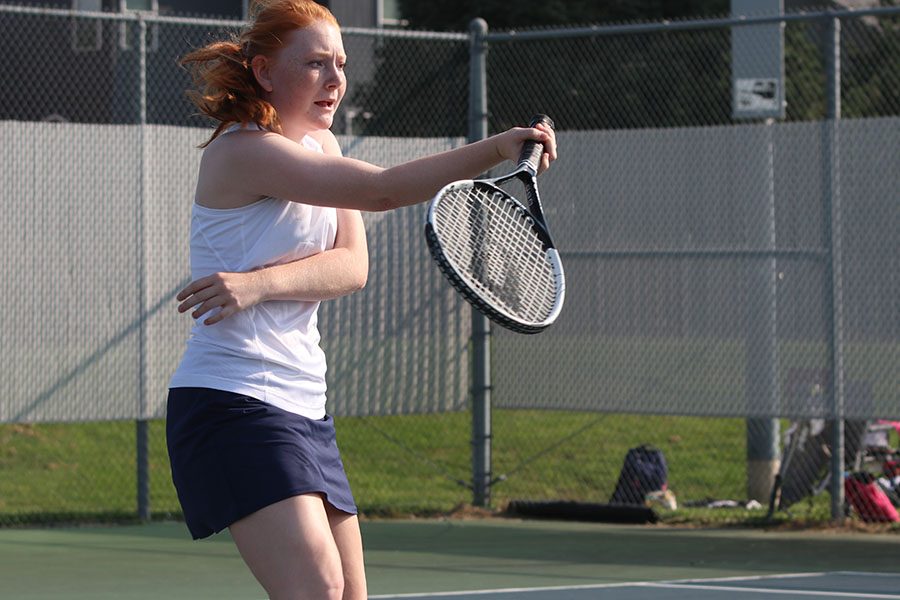 Extending her racket, sophomore Lauren Butler follows through on a forehand hit back to opponent Olathe Northwest. She and Carli Dupriest won their doubles match on Wednesday, September 4.