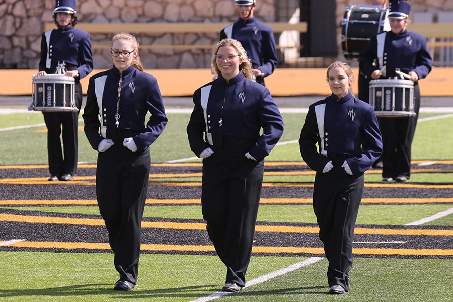 Drum majors seniors Amber Guilfoil, Kaleigh Johnston and junior Patty McClain lead the band onto the field to start their performance.