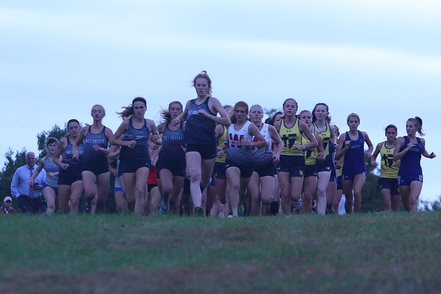 With a great start, junior Molly Ricker gets ahead of everyone and sets the pace for the race. The meet was held in Shawnee Mission Park Thursday, Oct. 10 with both the boys and girls getting first in their meets, and the girls also getting a perfect score. 