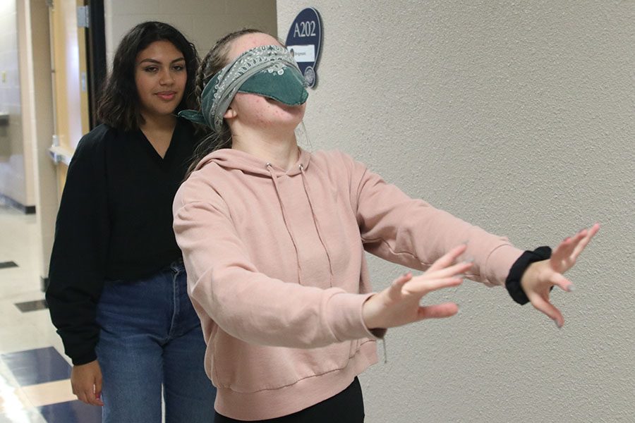 Being guided down upper A hall, sophomore Asilya Johnson puts her arms out. At the beginning of second quarter, psychology students participate in interactive project around the school.