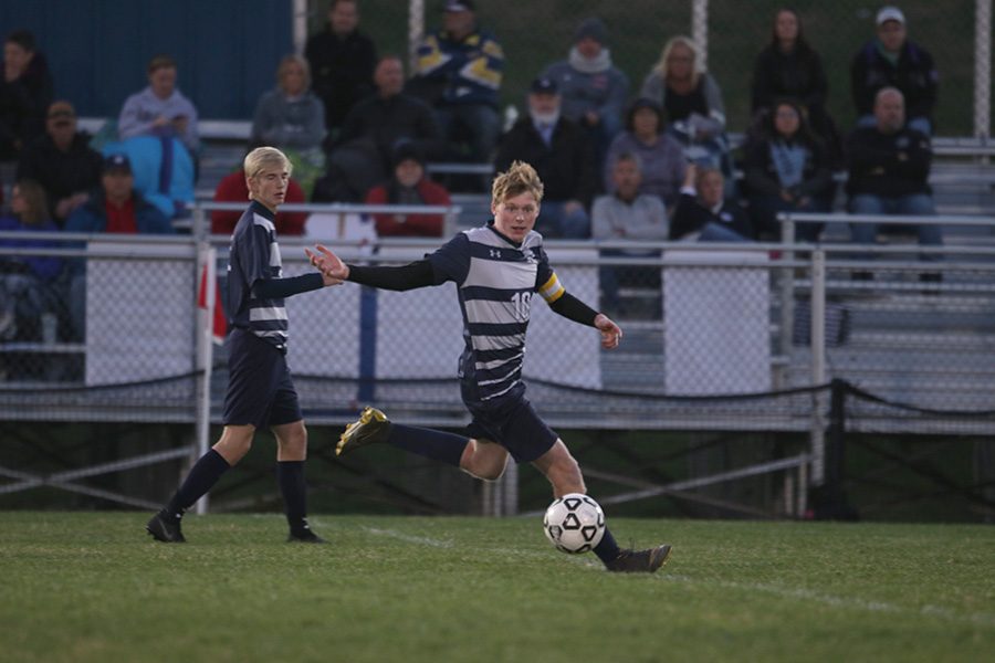 Looking to pass the ball, senior Will Coacher runs down the field. 