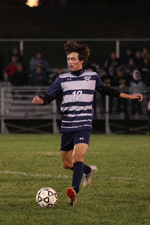 Senior Anthony Pentola dribbles the ball up the field.