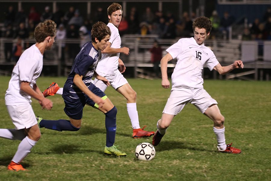 Dribbling by his opponents, sophomore Yahel Anderson heads towards the goal. The boys soccer team lost 1-0 in overtime on Tuesday, Oct. 22 against Blue Valley.