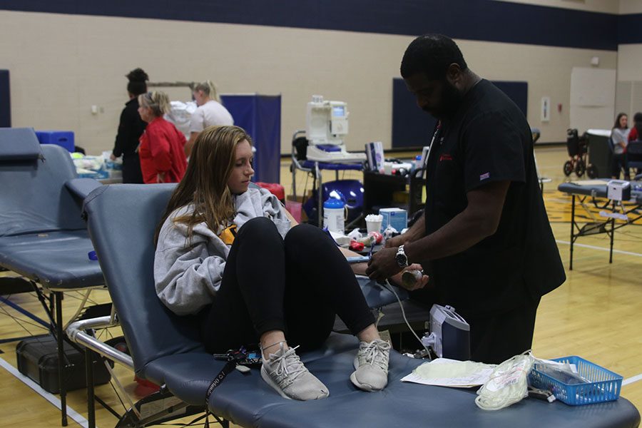 As the first person to give blood, senior Kylie Conner senior lies on the table waiting to finish her donation.