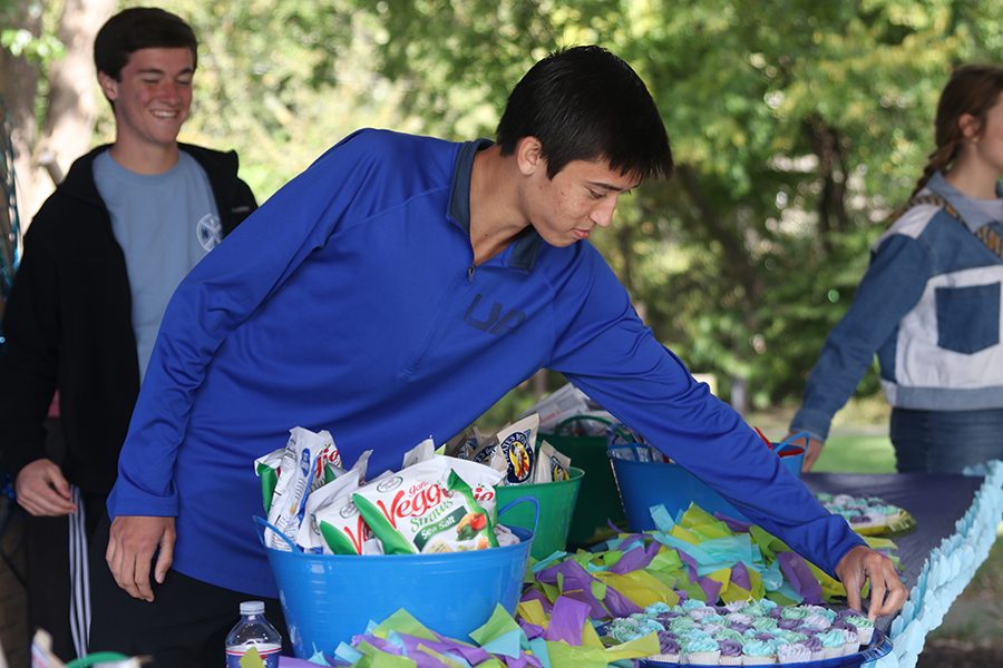 Replacing a cupcake that was taken, senior Josh Mansfield ensures the snack station runs smoothly. He, along with other NHS members, volunteered at the AdventHealth-sponsored NICU reunion Sunday, Oct. 20.