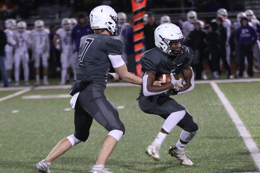 To confuse the Pittsburgh defense, junior Cooper Marsh hands the ball off to junior Quin Wittenauer. 