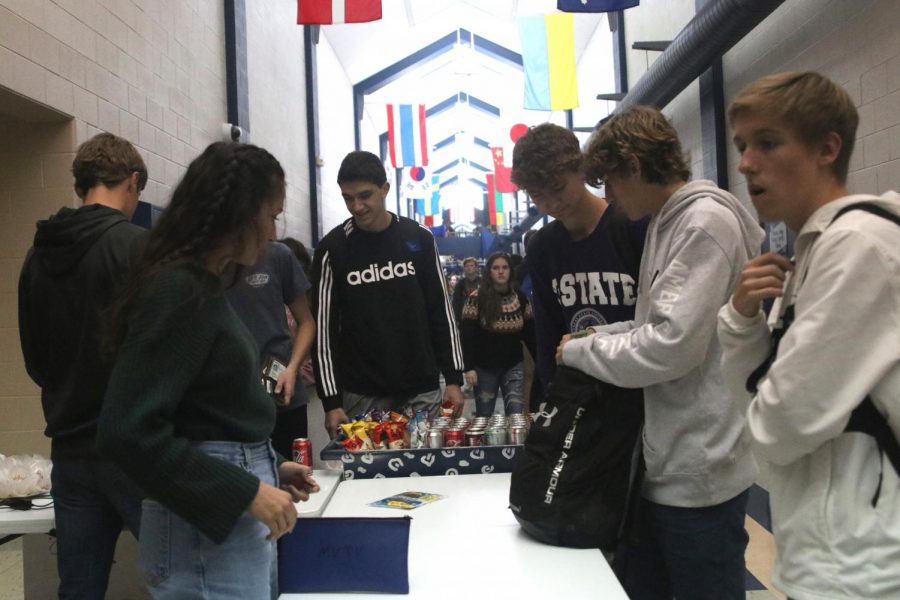 Standing at a table by the entrance of the theatre, sophomore Quincy Hubert sells tickets to students Tuesday, Oct. 29. There were also concessions being sold outside the little theatre.