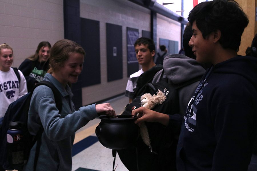 Putting her ticket in the pumpkin shaped bowl, sophomore Lauren Walker smiles as sophomore Danny Talavera greets her.“Enjoy the magic of the movies,” Talavera said Tuesday Oct. 30.