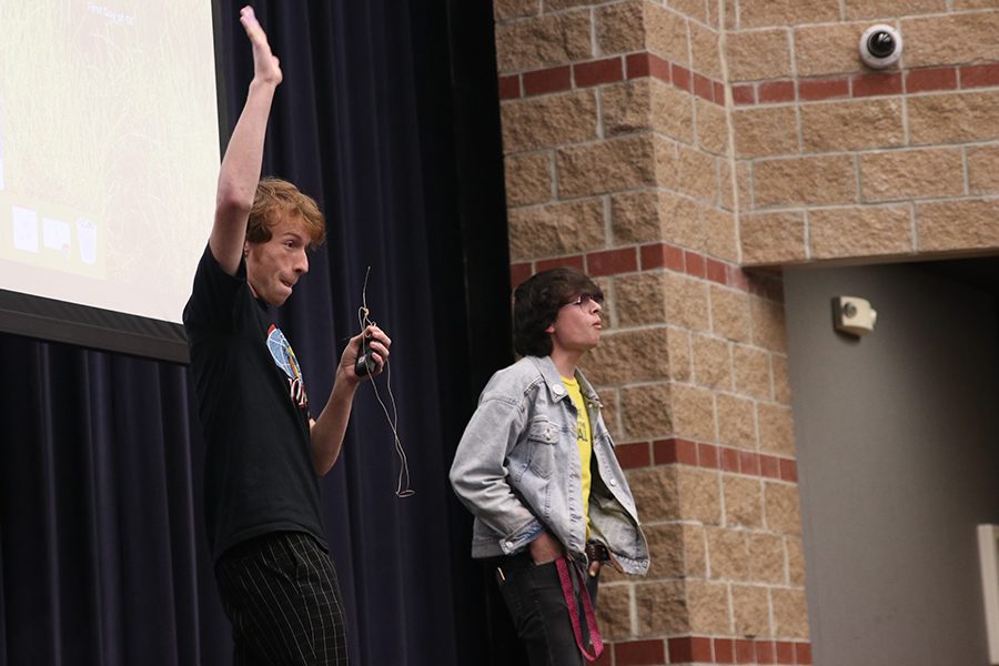 Raising his hand in the air, senior Bennett Doyle arouses the crowd while he explains the directions for the event.