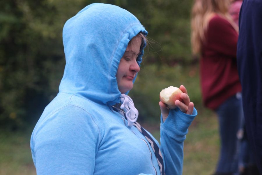 Enjoying what she earned at the orchard, student Maria McElwee enjoys one of the apples she picked by hand.
