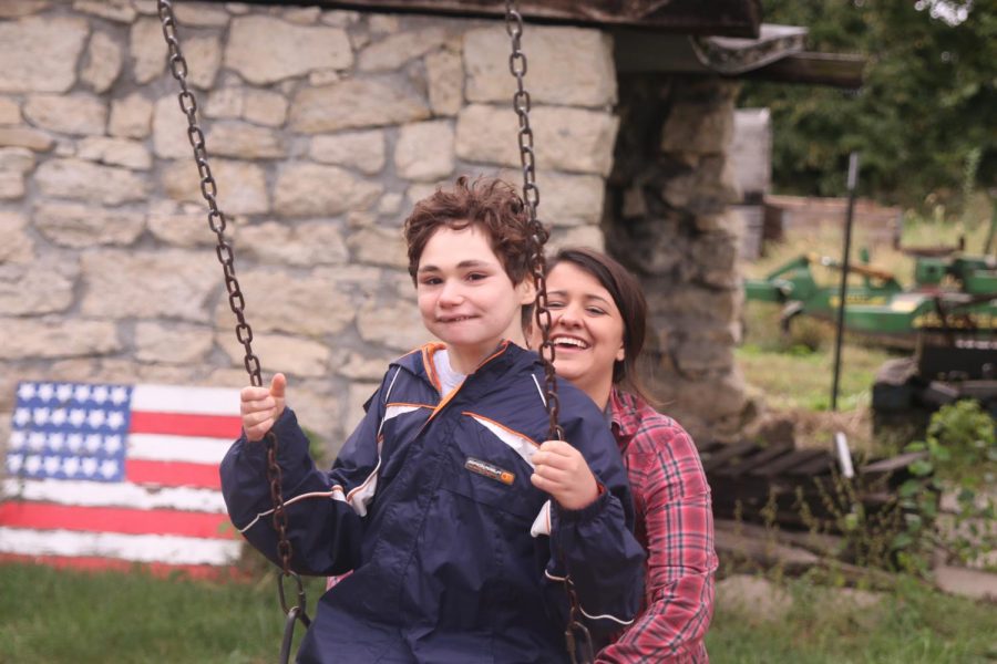 At the apple orchard, senior Rachel Sunderman helps push junior Charlie Peterson on the swing.
