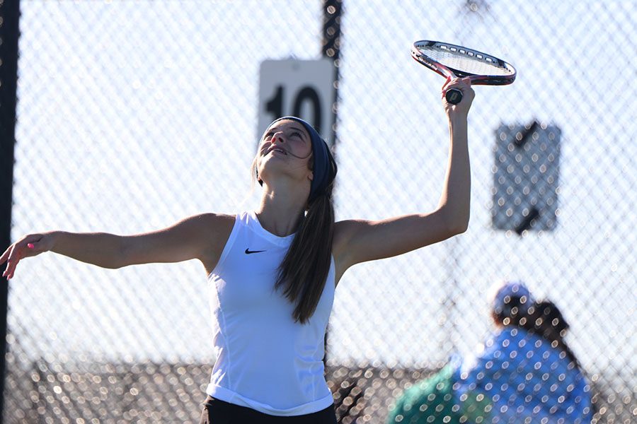 Sophomore Olivia Lecuru reaches up to send the tennis ball over the net. 