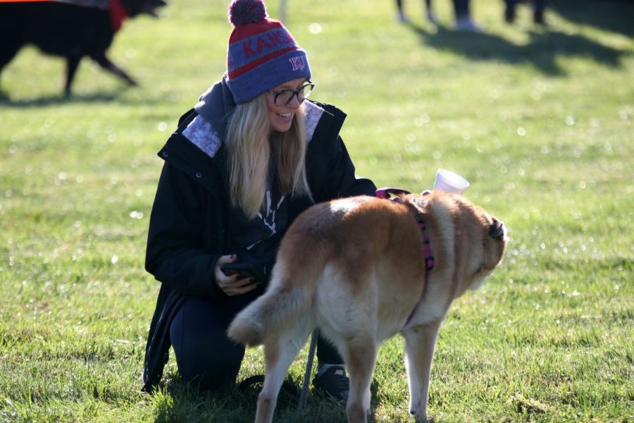 Smiling, senior Ashlyn Dempsey pets her dog.