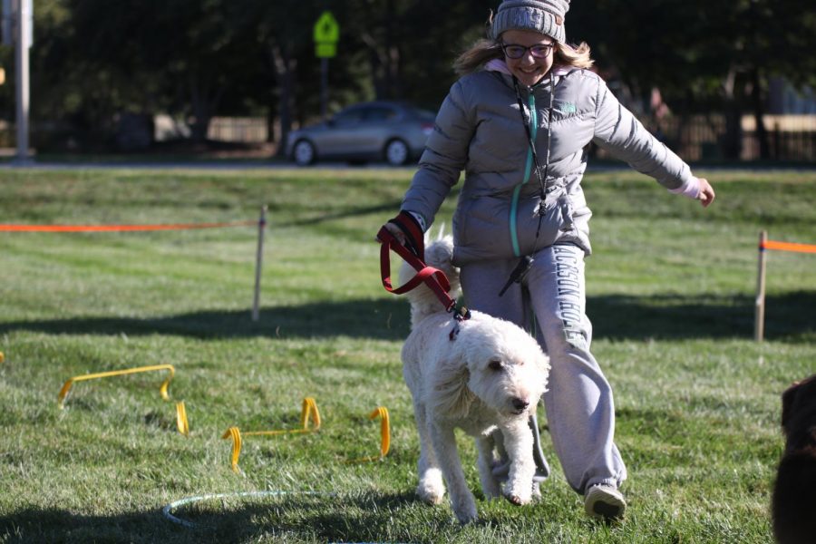 Participating in the obstacle course, freshman Bella Mehner runs alongside her dog.