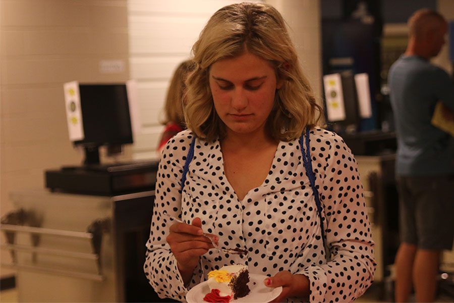 After the induction ceremony, senior Hannah Davie enjoys a piece of cake. 