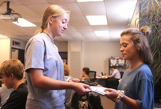 After junior Sophia Dawson (right) buys a sticker, sophomore and Silver Stars dance team member Hadley Skinner (left), hands her a sticker. 