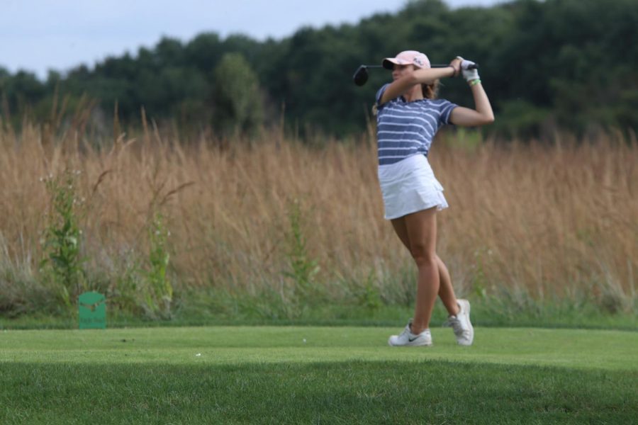 Watching the ball, junior Caroline Lawson finishes her swing at Eagle Bend Golf Course on Wednesday, Oct. 2nd.