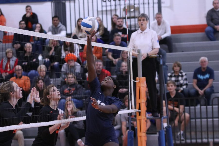 Arm extended, sophomore Taylor Roberts tips the ball over the net.