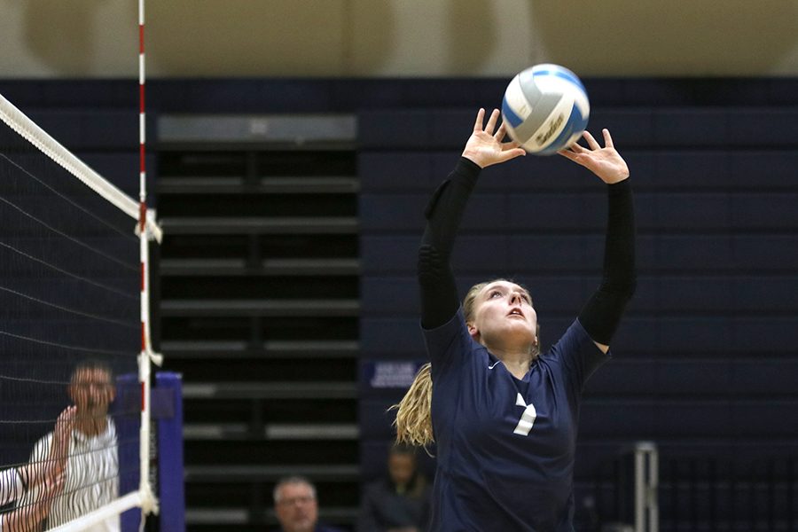 Extending her arms, sophomore Sydney Fiatte uses her fingers to set the ball to her teammate. The team competed in a triangular at St. Thomas Aquinas against Aquinas and Bishop Miege on Tuesday, Oct. 15. They beat Miege 2-0 but lost to Aquinas 0-2.