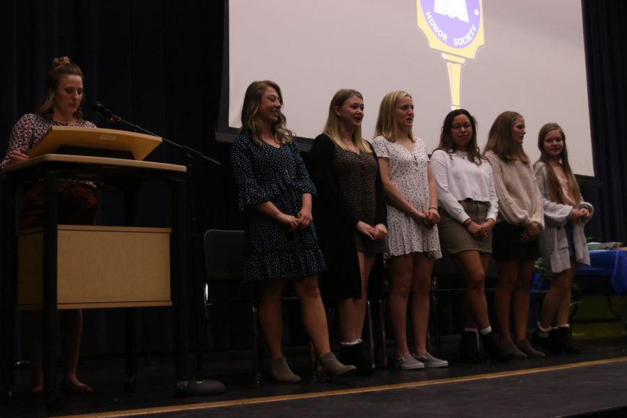 Standing on stage, seniors Allison Gourd, Anna Ricker, Tina Talavera and juniors Emma Schieber and Emily Feuerborn recite the English NHS oath. The club held its induction ceremony Wednesday, Oct. 23.