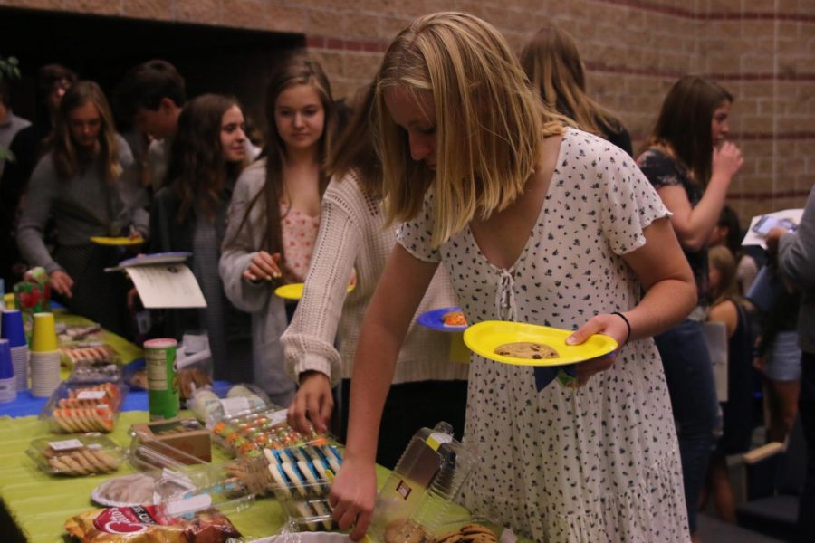Grabbing a cookie, senior Anna Ricker celebrates the English HS induction ceremony on October 23.