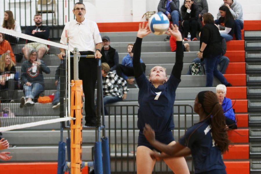 Arms extended above her head, sophomore Sydney Fiatte sets the ball for her teammate. 