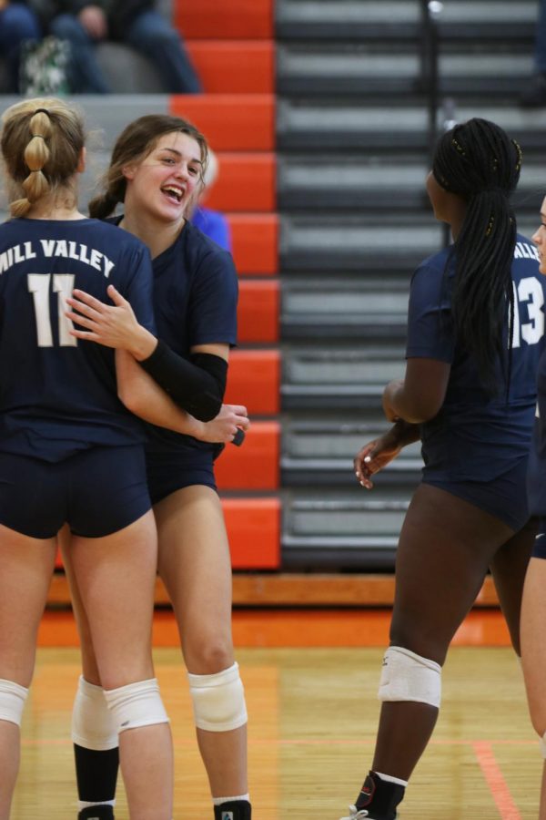 After scoring a point, junior Molly Carr celebrates with her teammate at the net.