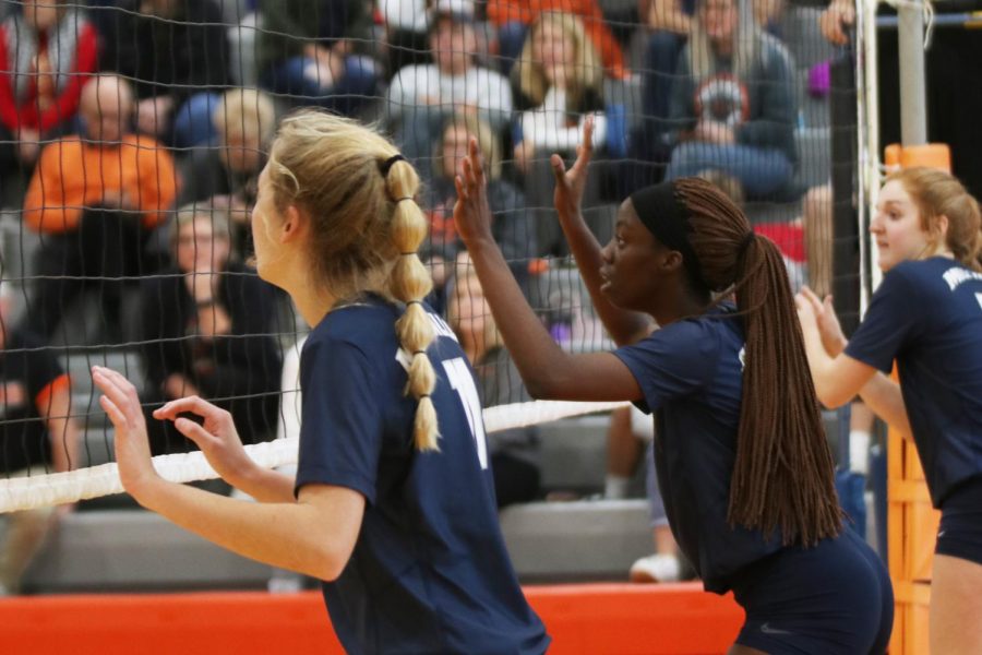 Her attention on the opposing team’s server, senior Faith Archibong clings to the net.