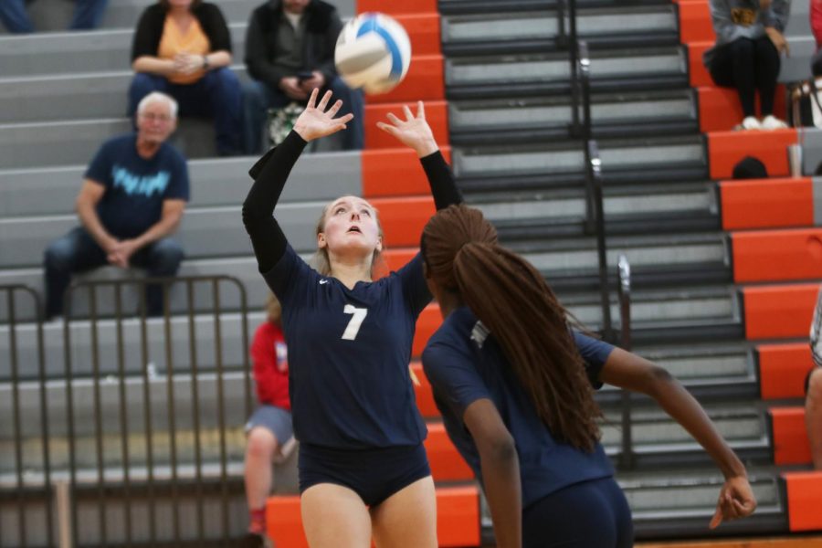 Arms raised above her head, sophomore Sydney Fiatte sets the ball for a teammate. 
