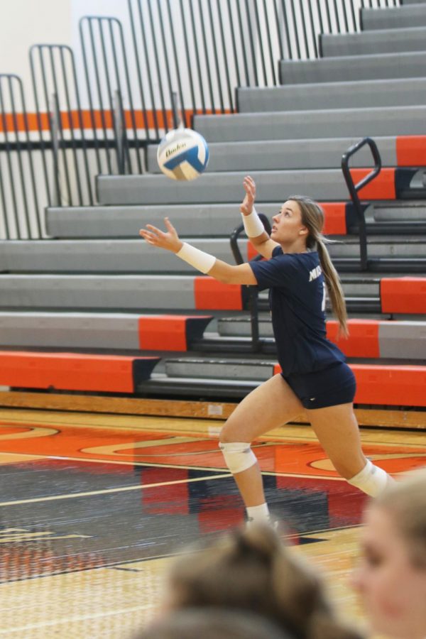 After tossing the ball in the air, senior Emma Fox prepares to serve it over the net. 